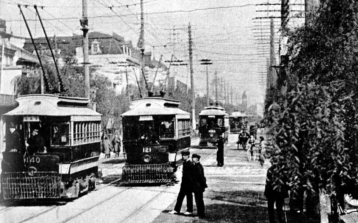 Tram elettrico percorre Ginza a Tokyo nel 1912 lungo una strada alberata e affollata.